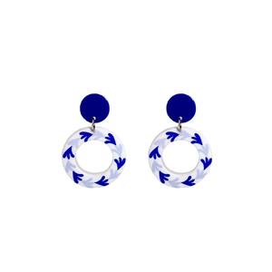 Detailed view of blue and white porcelain style acrylic earrings with floral patterns