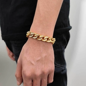 Close-up of a 12mm gold CNC diamond-set Cuban link bracelet on a male model's wrist