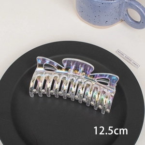 Macro shot of a 12.5cm large holographic laser hair claw clip on a grey tray