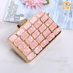 Detail of pink marble acrylic evening clutch with gold metal frame and chain strap