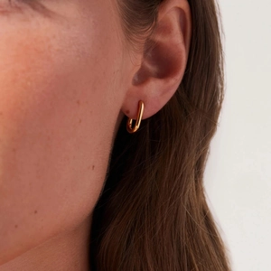 Minimalist 14K gold plated stainless steel U-shaped hoop earrings worn on a female model
