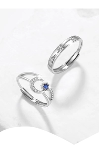 Macro shot of 925 silver couple rings featuring blue zircon moon and star relief design