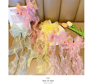 Detailed view of floral mesh bow hair clips in pink and blue for little girls