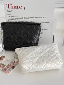Detail of heart quilted storage bags in black and white with elegant pearl charms