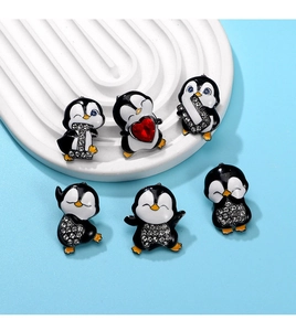 Macro shot of six crystal penguin charms with enamel finish and metal accents
