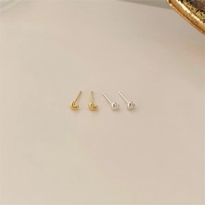 Detail of minimalist 925 silver heart stud earrings in gold and silver finishes