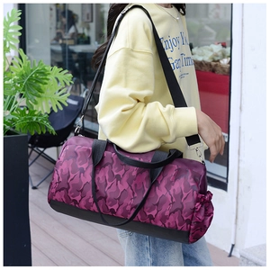 Action shot of purple camo nylon travel duffel bag worn as a crossbody fitness bag