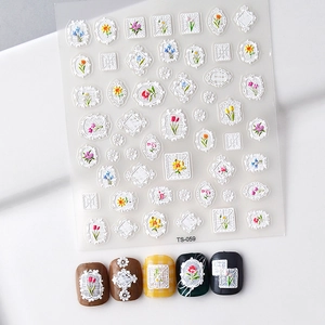 Macro shot of 5D white floral lace embossed nail stickers shown on various base colors