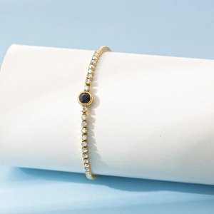 Vue détaillée du bracelet en acier doré avec pierre noire et cristaux multicolores