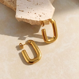 Élégantes boucles d'oreilles rectangulaires en U en acier plaqué or sur socle beige