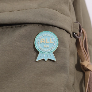 Creative enamel medal brooch with medical patterns pinned on a green canvas bag