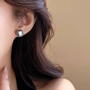 Macro view of geometric square silver earrings with a polished mirror finish on model