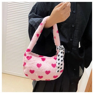 Detail of pink plush heart shoulder bag featuring a polka dot silk scarf handle accent