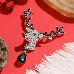 Detail of Christmas reindeer brooch with black and white rhinestones on a festive red background