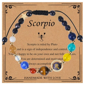 Macro detail of handmade Scorpio bracelet with blue goldstone beads on display card