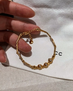 Detailed macro view of 18K gold plated bamboo link bracelet with zircon beads