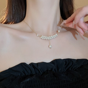 Elegant double-layered faux pearl necklace with gold chain on model neck