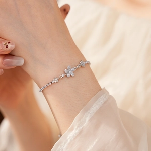 Primo piano di un elegante bracciale a fiori in argento con zirconi al polso