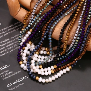 Handmade necklace with faceted crystals and freshwater pearls on a wooden hand model
