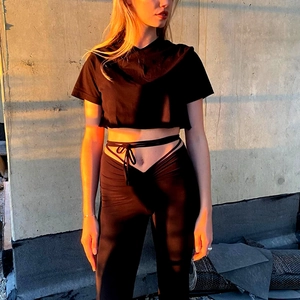 Close-up of black yoga set featuring V-waist leggings with stylish cross-strap detail