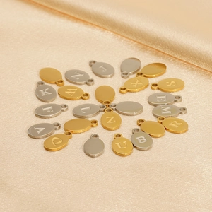 Polished gold and silver letter pendants A-Z on silk background for jewelry making