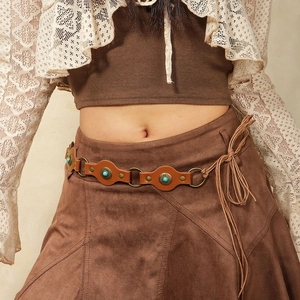 Close-up of bohemian brown leather belt with turquoise inlay and silver rings