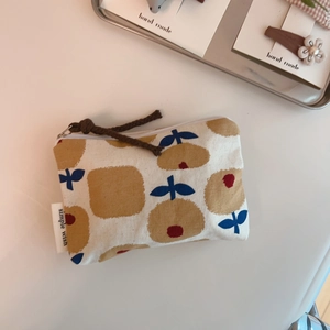 Close-up of floral cotton coin purse with simple wish label and brown cord zipper pull