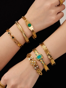 Detailed close-up of six gold-plated bangles featuring green stones and zircon inlay
