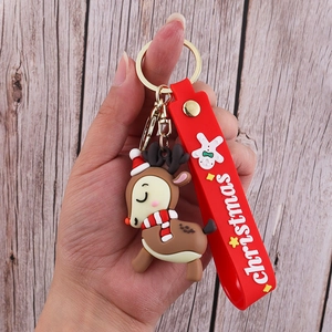 Close-up of a brown 3D reindeer PVC keychain with a red Christmas silicone wrist strap