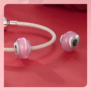 Macro shot of s925 sterling silver pink cat eye stone bead on woven silver bracelet