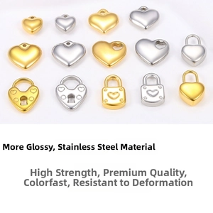 Macro shot of assorted heart and lock-shaped stainless steel charms in gold and silver