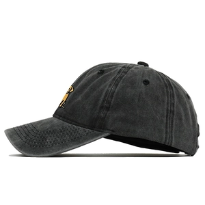 Gros plan sur la casquette en coton noir délavé avec broderie de chien jaune et coutures
