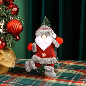 Detail of plush Santa Claus ornament hanging on Christmas tree with snowflake button