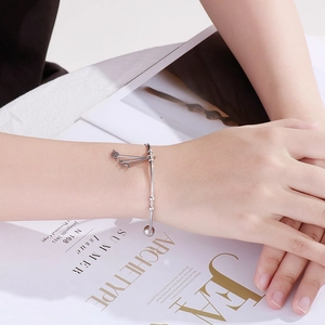 Silver celestial open bangle with moon star and planet charms on fashion magazine