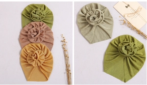 Detail of baby turban hats with large flower knots in green, pink and yellow knit