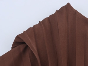 Detailed macro view of dark brown vertical pleated fabric with premium draped texture