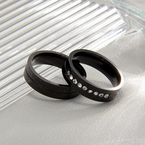 Macro detail of black titanium steel rings featuring a minimalist groove and pavé zircon stones