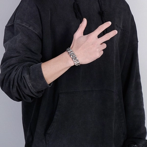 Close-up of a men's chunky silver snake pattern steel bracelet on a male wrist