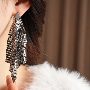 Close-up of model wearing gunmetal long fringe earrings with geometric triangle base