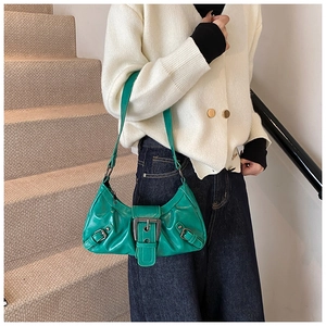 Detail of green patent leather crescent bag with silver buckle in a Y2K aesthetic