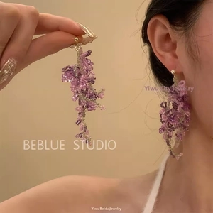 Détail de boucles d'oreilles pendantes en perles violettes pour style de vacances