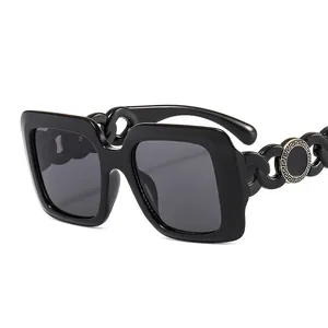 Fashionable oversized square black sunglasses with luxury gold Greek key chain temples