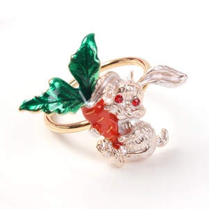 Detailed view of silver rabbit napkin ring with orange enamel carrot and red gem eyes