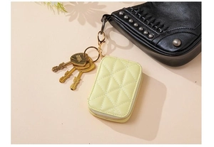 Close-up of quilted light yellow coin purse with gold zipper and key ring attachment