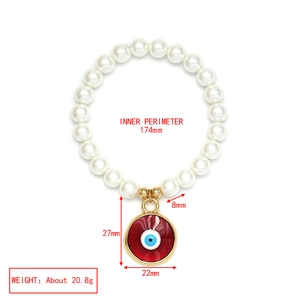 Detail der Maße des roten Evil-Eye-Anhängers und der weißen Perlen am Armband