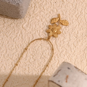 Détail du collier en acier plaqué or 18K avec pendentif fleur de lotus et feuilles d'or
