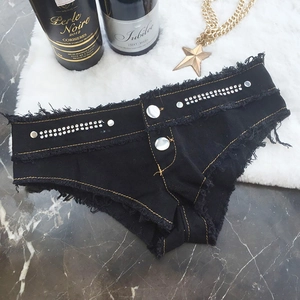 Details schwarzer Denim-Shorts mit Fransen und Strassbesatz auf dekorativem Hintergrund