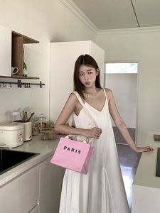 Detail of pink straw tote bag with black Paris embroidery and canvas straps