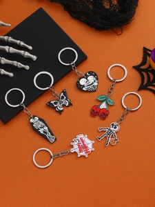 Macro view of six Halloween keychains with skull, spider web and cherry motifs