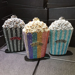 Detailed view of three popcorn-shaped luxury rhinestone evening bags in various stripes